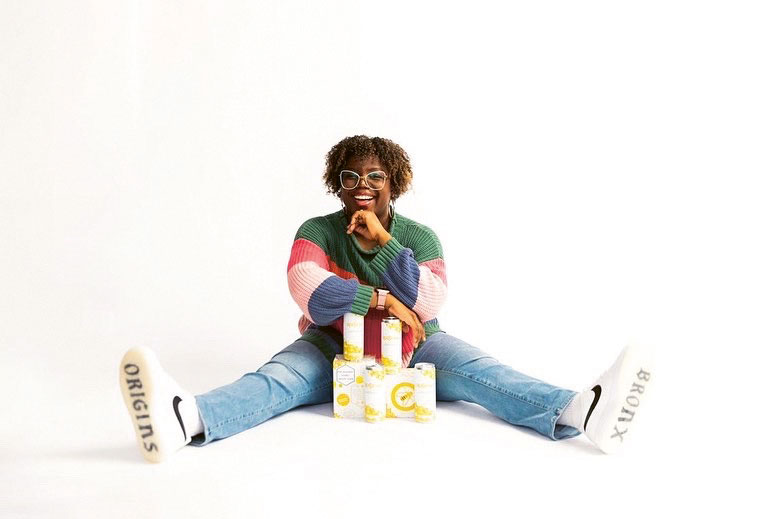 Image of Lauren "LP" Paylor O'Brien sitting with cans of Siponey