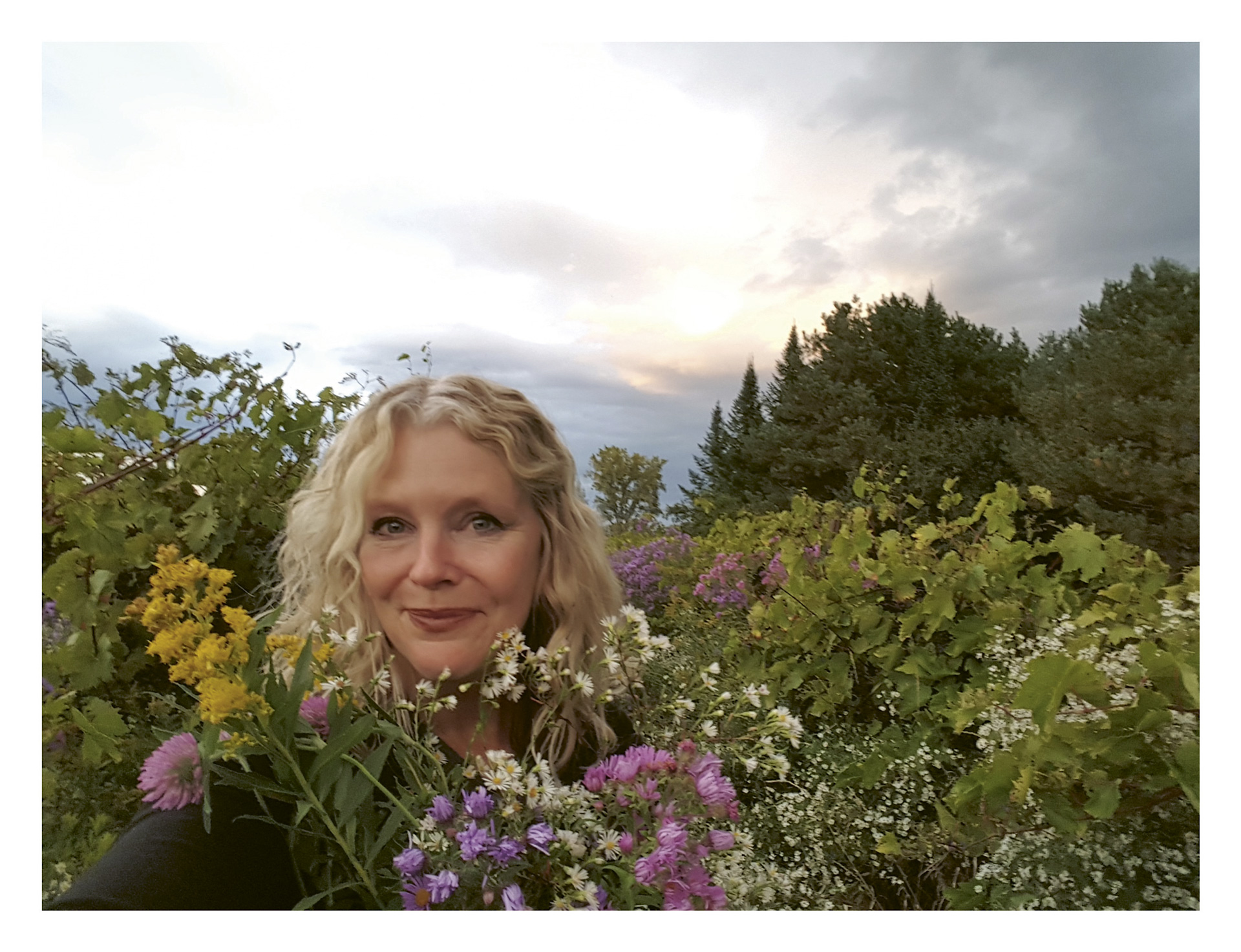 Photograph of Deirdre Heekin of La Garagista in Vermont, pictured in a field surrounded by flowers