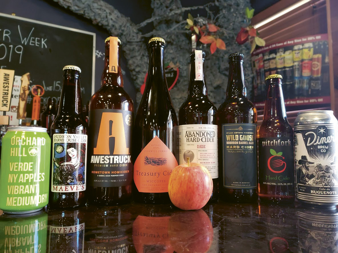 Bottles of various hard ciders lined up on a counter at Boutique Wines, Spirits and Ciders in Fishkill, NY