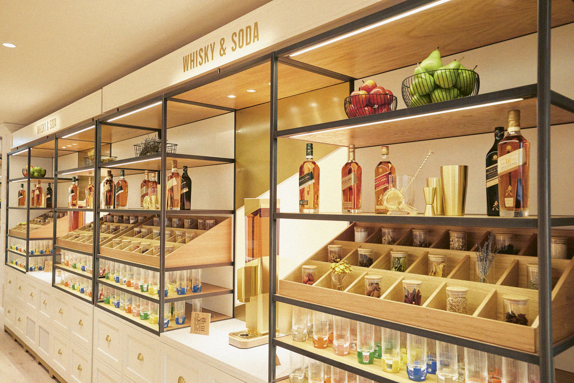A selection of cocktail-making ingredients line shelves along with bottles of Johnny Walker at the Johnny Walker Princes Street location