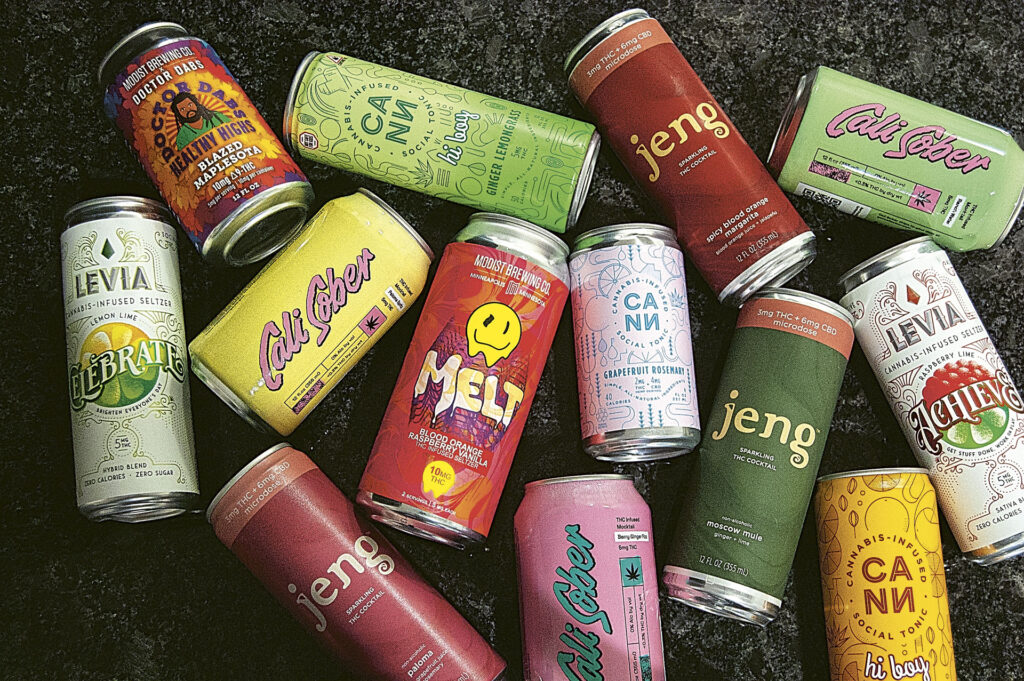 WEB_DSC_2757_CMYK_Fin Cans of various cannabis-infused beverages lying flat and shot overhead on a granite countertop.