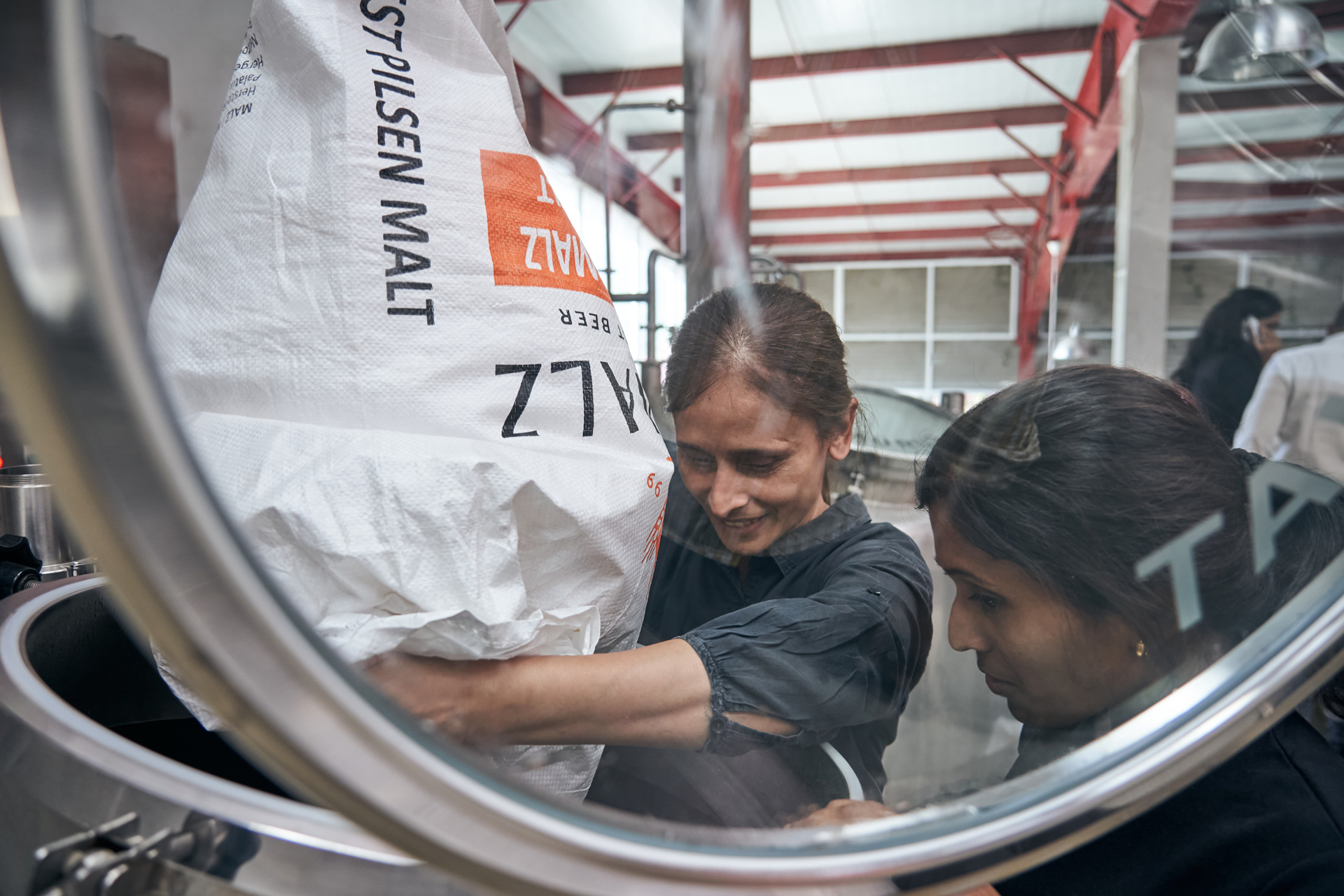 Geist Head Brewer Vidha Kubher mashing in malt into a kiln for Straosphere Lager