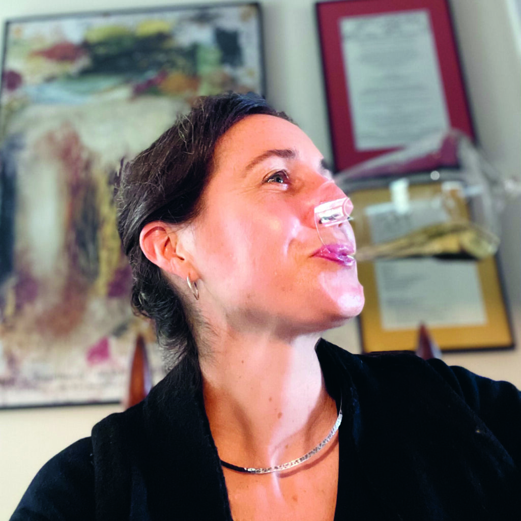 VK Headshot Dec 21 Headshot of writer Valerie Kathawala, drinking from a wine glass.