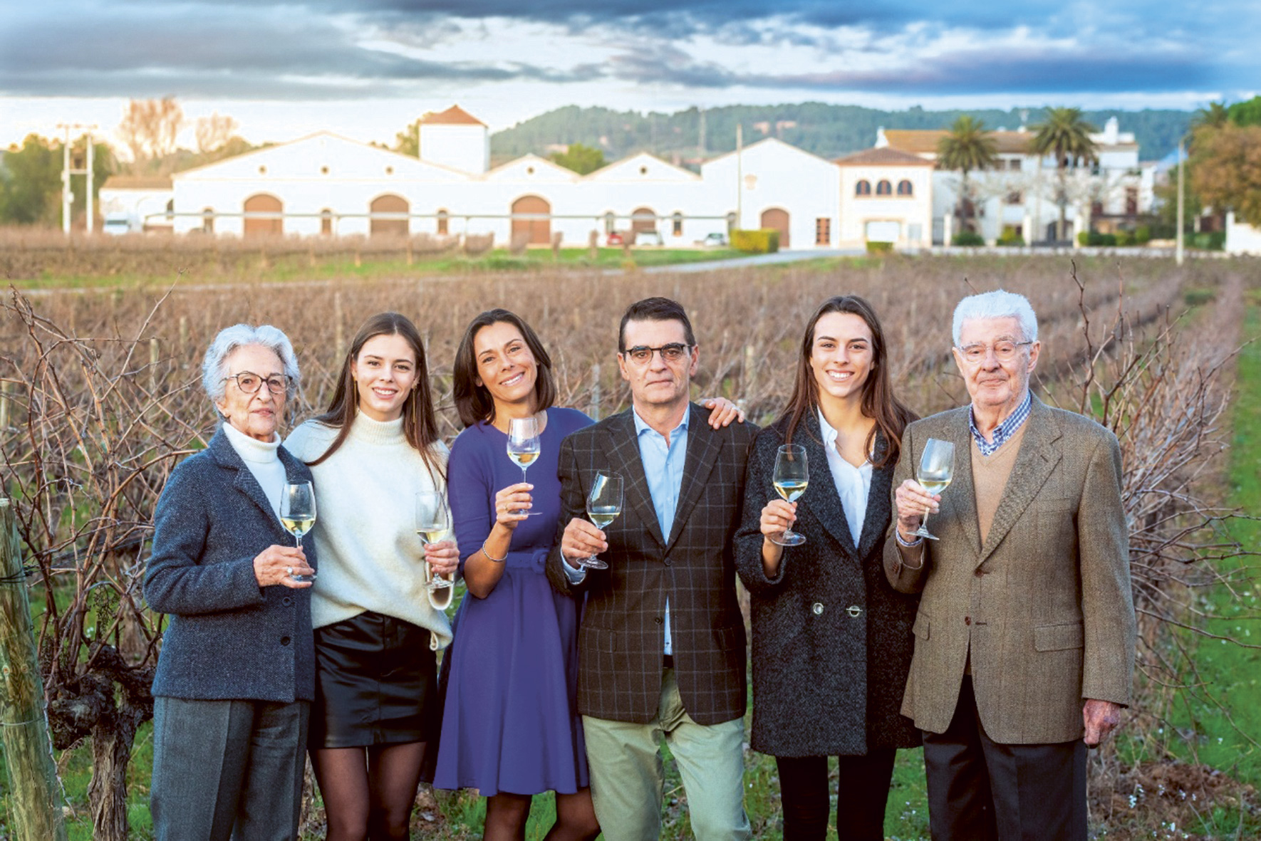 A picture of the Nadal family in front of their winemaking facility and vineyards in Corpinnat, Spain