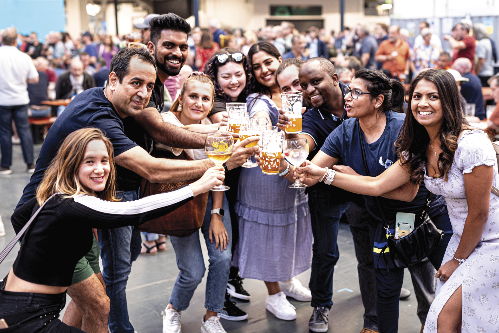 Great British Beer Festival attendees cheersing with glasses of beer in support of CAMRA in London