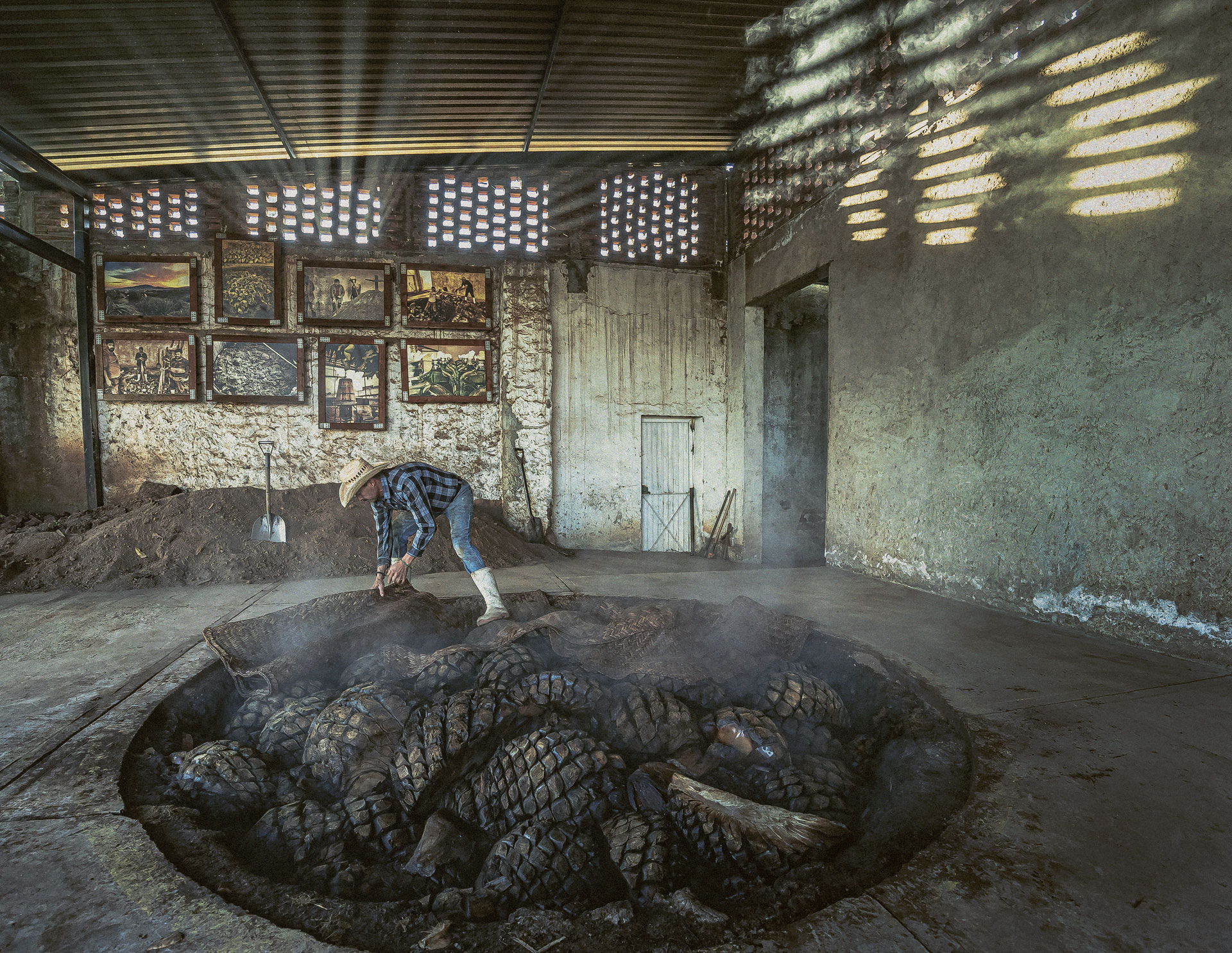A pit oven filled with agave hearts, smoking in production, at Cascahuin Distillery used for making Siembra Valles Tequila