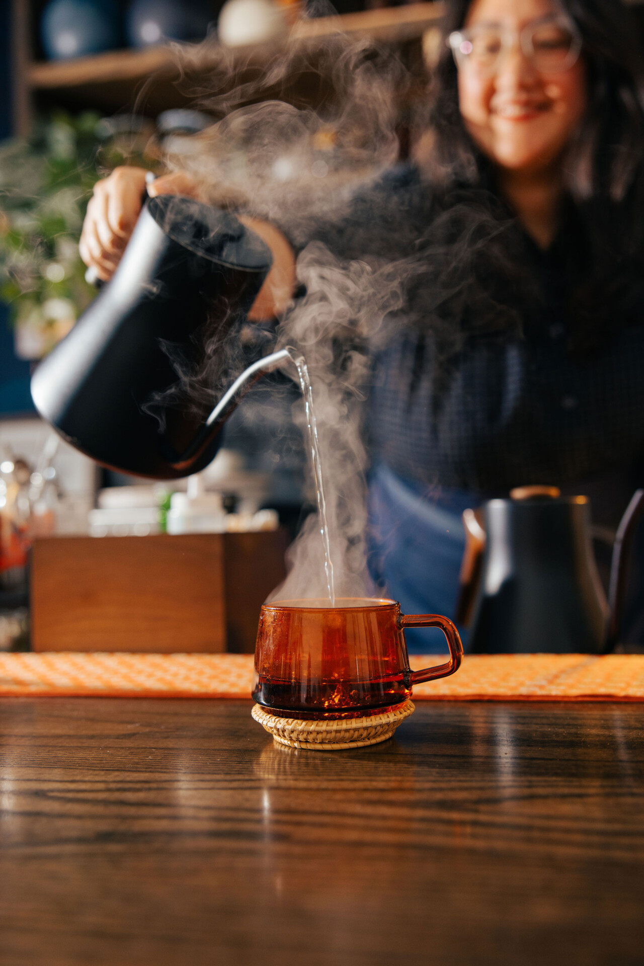 Hot sake being poured by Alyssa DiPasquale into a mug on the bar at The Koji Club