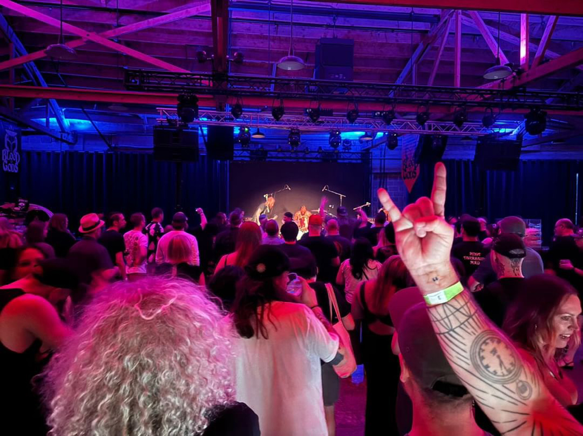 Photograph of a crowd watching a blue-lit stage at Blood of Gods' Annual Merrymaking Event